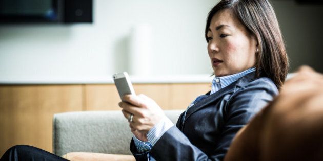 woman using smartphone on couch