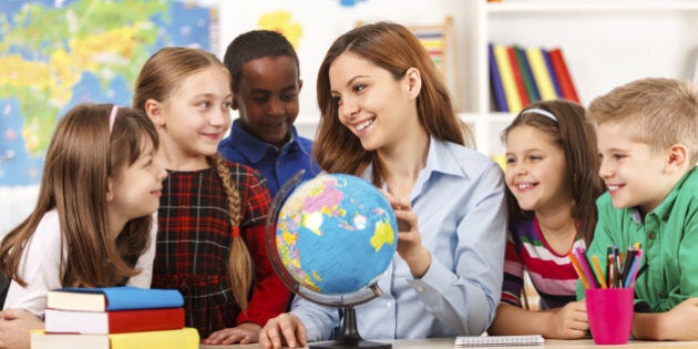 Teacher and children looking at globe