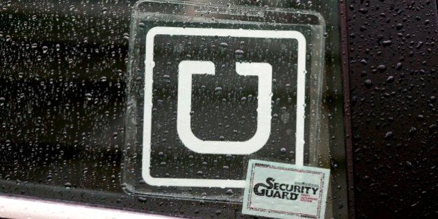 The Uber Technologies Inc. logo is displayed on the window of a vehicle after dropping off a passenger at Ronald Reagan National Airport (DCA) in Washington, D.C., U.S., on Wednesday, Nov. 26, 2014. Uber Technologies Inc. investors are betting the five-year-old car-booking app is more valuable than Twitter Inc. and Hertz Global Holdings Inc. Photographer: Andrew Harrer/Bloomberg via Getty Images