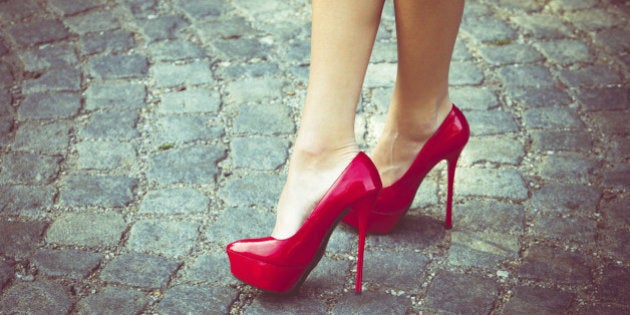 woman legs in red high heel shoes outdoor shot on cobble street