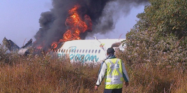 This photo taken on December 25, 2012 shows a man walking the fuselage of an Air Bagan passenger plane burn after it crashed near Heho airport in Myanmar's eastern Shan state. The Myanmar ageing Fokker-100 plane carrying 65 passengers including foreign tourists crash-landed in eastern Shan state, leaving two people dead and 11 others injured, the airline and officials said. AFP PHOTO (Photo credit should read STR/AFP/Getty Images)