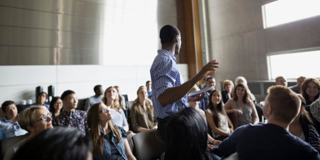 Professor giving lecture among auditorium audience