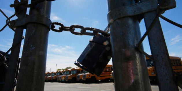 The gates of a school bus yard are locked after drivers walked off the job in the morning in Boston, Massachusetts October 8, 2013. Boston Mayor Thomas Menino vowed to punish school bus drivers who walked off the job on Tuesday in a labor action the city contended was illegal, and which even the drivers' union organization condemned. Some 33,000 public and private school students were left to find alternative routes to school on Tuesday after a union representing some 700 drivers and also represented by the United Steelworkers of America Local 8751 did not show up for work. REUTERS/Brian Snyder (UNITED STATES - Tags: BUSINESS EMPLOYMENT TPX IMAGES OF THE DAY)