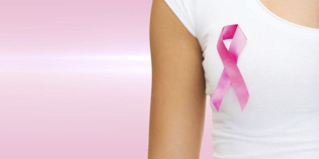 healthcare and medicine concept - woman in blank t-shirt with pink breast cancer awareness ribbon