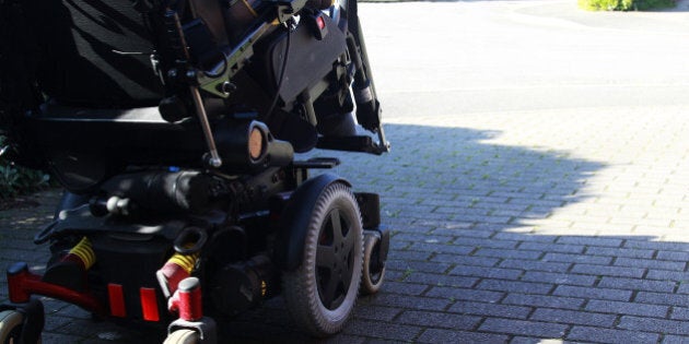 side view of disabled man driving an electric wheelchair