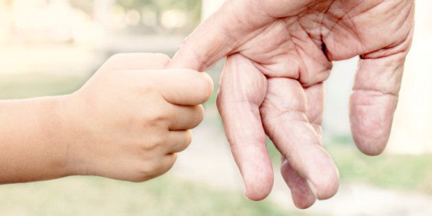 Young child holding her grandparent for the hand,selective focus