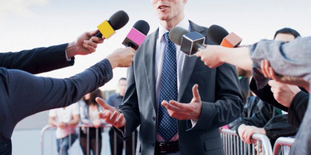 Politician talking into reporters' microphones