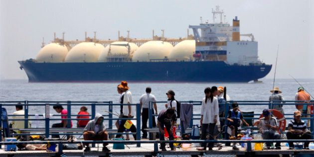 JAPAN - JUNE 20: A liquefied-natural-gas (LNG) tanker, leaves a berth as holidaymakers fish on a pier in Yokohama City, Kanagawa Prefecture, Japan, on Saturday, June 20, 2009. The world LNG market is likely to face supply shortages around 2013 as new projects fail to keep pace with supply, according to Wood Mackenzie, a U.K. energy research and consulting company. (Photo by Kimimasa Mayama/Bloomberg via Getty Images)