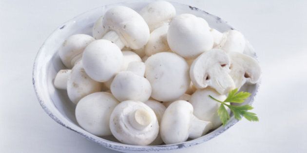 White button mushrooms in bowl, close up