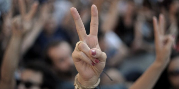 Anti-goverment protestors flash the victory sign on Taksim square during a demonsration against the government in Istanbul on June 25, 2013. Erdogan yesterday praised the police 'heroism' in handling several weeks of unrest that threw up the biggest challenge yet to his government after more than a decade in power. AFP PHOTO/OZAN KOSE (Photo credit should read OZAN KOSE/AFP/Getty Images)