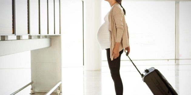 Pregnant woman looking at departure monitor