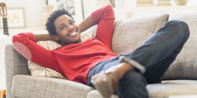 Man lying on sofa and smiling