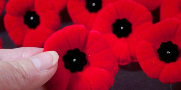 [UNVERIFIED CONTENT] The red poppy is a symbol of remembrance for all the men and women who fought in war. This design is Canadian. A hand is selecting a pin from many.
