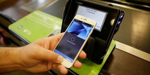 FILE - In this photo taken Friday, Oct. 17, 2014, Eddy Cue, Apple Senior Vice President of Internet Software and Services, demonstrates the new Apple Pay mobile payment system at a Whole Foods store in Cupertino, Calif. Apple launched the payment system that sidesteps wallets, the latest way for people to use their phones instead of cash or plastic to pay stores. (AP Photo/Eric Risberg, File)