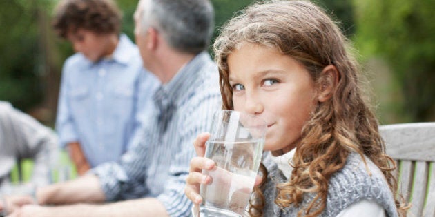 Girl drinking water at picnic table