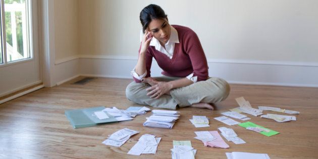 Woman looking at bills and receipts on floor