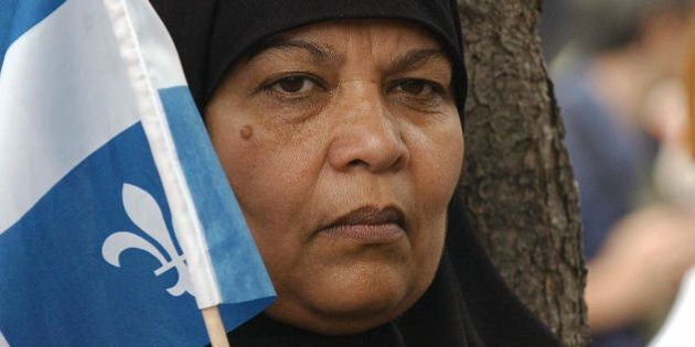 A Pakistani woman holds a Quebec flag during a demonstration called 'No One is Illegal' against the World Trade Organization meeting 27 July 2003 in Montreal. At the WTO's informal meeting starting 28 July 2003, trade ministers will attempt to find common ground over the divisive issues of farm subsidies and medicine for poorer countries that have stalled the latest round of global trade talks. AFP PHOTO/Normand BLOUIN (Photo credit should read NORMAND BLOUIN/AFP/Getty Images)