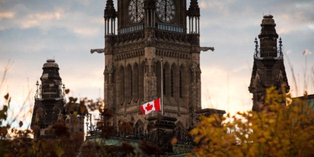 OTTAWA, ON - OCTOBER 23: A flag next to the Canadian Parliament Building is flown at half-staff one day after Cpl. Nathan Cirillo of the Canadian Army Reserves was killed while standing guard in front of the National War Memorial by a lone gunman, on October 23, 2014 in Ottawa, Canada. After killing Cirillo the gunman stormed the main parliament building, terrorizing the public and politicians, before he was shot dead. (Photo by Andrew Burton/Getty Images)