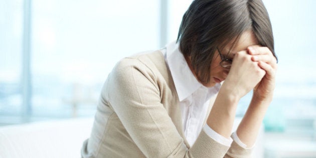 Portrait of tired woman touching her head