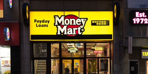 DOWNTOWN, TORONTO, ONTARIO, CANADA - 2015/08/23: People walking in front of a Money Mart store in Toronto. National Money Mart Company, commonly known as Money Mart, is a Canadian financial services company that provides payday loans, cheque cashing, tax preparation and money transfer services to the underbanked. (Photo by Roberto Machado Noa/LightRocket via Getty Images)