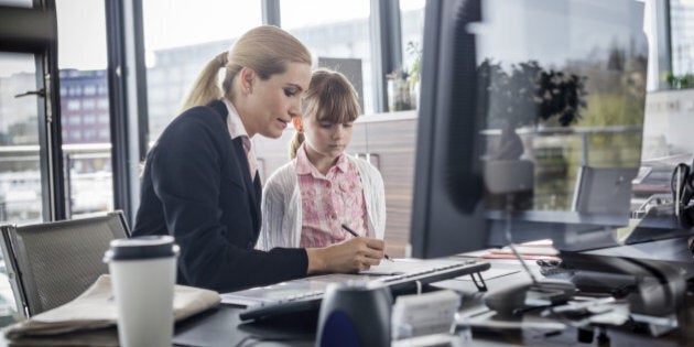 A modern working woman is visited by her daughter at work Horizontal shot.