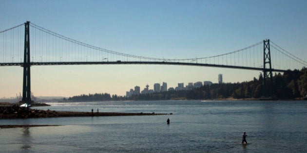 Fishermen stand at the mouth of the Capilano River fishing for salmon in West Vancouver, British Columbia August 25, 2010. The Pacific Salmon Commission announced it expects as many as 25 million fish will return the largest return since 1913. The Lions Gate Bridge is seen in the background. REUTERS/Andy Clark (CANADA - Tags: CITYSCAPE ANIMALS FOOD ENVIRONMENT BUSINESS)