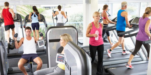 Elevated View Of Busy Gym With People Exercising On Machines