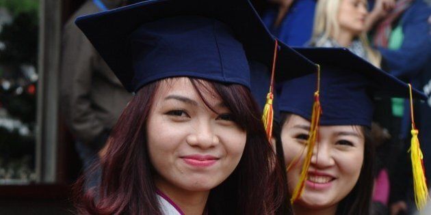 Two students from a local college attend a graduation ceremony at the Temple of Literature in Hanoi on November 18, 2014. The temple is where Vietnam's oldest university was founded in the 11th century under the Ly Dynasty, and is popular with modern-day students who begin to flock in high school, hoping to boost their chances in annual nationwide examinations. AFP PHOTO / HOANG DINH NAM (Photo credit should read HOANG DINH NAM/AFP/Getty Images)