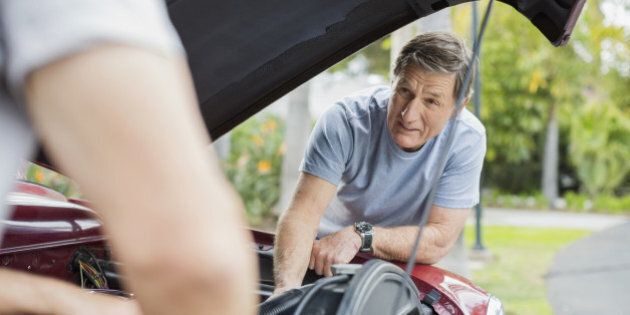 Senior men repairing car engine