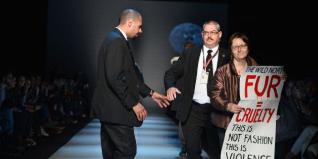 TORONTO, ON - MARCH 27: Security escorts a protester holds an anti-fur off the runway during the show for The Wild North fall 2015 collection during World MasterCard Fashion Week Fall 2015 at David Pecaut Square on March 27, 2015 in Toronto, Canada. (Photo by George Pimentel/Getty Images for IMG)