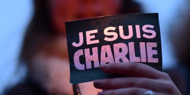A woman holds a sign reading 'Je suis Charlie' (I am Charlie) during a gathering in Brussels on January 9, 2015 to pay tribute to the victims of a deadly attack on the Paris headquarters of French weekly Charlie Hebdo. Elite commandos units killed the two suspects in the Charlie Hebdo massacre during a simultaneous assault on the building they were holed up in and on a Paris Jewish supermarket, freeing hostages at both sites. AFP PHOTO / EMMANUEL DUNAND (Photo credit should read EMMANUEL DUNAND/AFP/Getty Images)