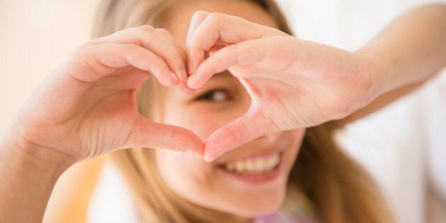 Caucasian girl making heart shape with hands