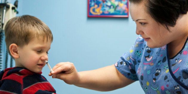 Three-year-old Clayton Mathiason, of Omaha, Neb., receives a dose of Swine Flu vaccine via nasal spray from nurse Amanda Stern at Physician's Clinic, affiliated with Omaha's Methodist Health System, in Omaha, Neb., Tuesday, Oct. 6, 2009. (AP Photo/Nati Harnik)