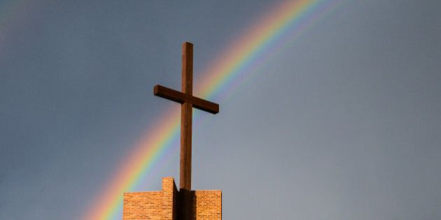 Rainbow behind a cross and grey sky