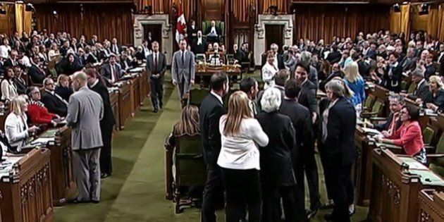 This photo from video provided by the Canadian House of Commons shows Canadian Prime Minister Justin Trudeau,near Opposition whip Gordon Brown in the House of Commons in Ottawa, Ontario on Wednesday May 18, 2016. Footage from the House of Commons television feed shows Trudeau wading into a clutch of lawmakers, mostly opposition members, and pulling a lawmaker through the crowd in order to get the vote started. As Trudeau turns around to pull the lawmaker through, lawmaker Ruth Ellen Brosseau can be seen reacting with discomfort. (House of Commons via The Canadian Press via AP) MANDATORY CREDIT
