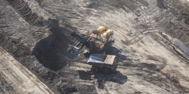 Aerial photo of a large power shovel excavating huge amounts of rock and sand into a dump truck.