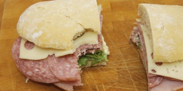 Italian sandwich on a well used cutting board less one big bite