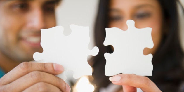 Mixed race couple holding puzzle pieces