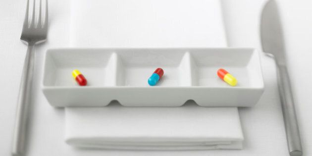 Close up of three pill capsules in sectioned dish