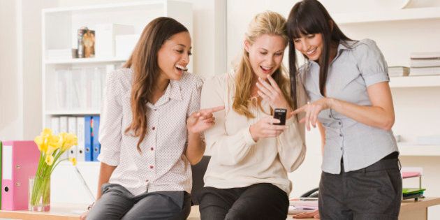 Stylish businesswomen in office with cell phone