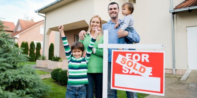 Happy family in front of their new house