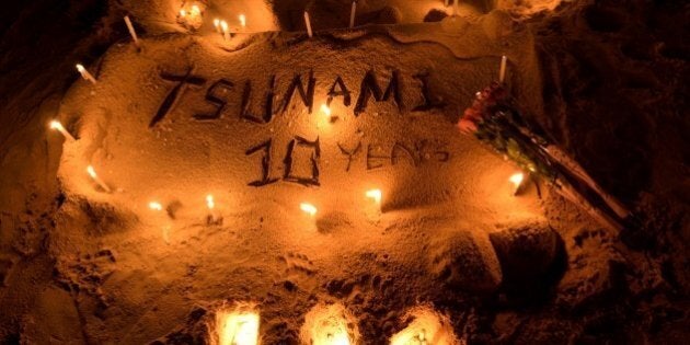Candles on a sand sculpture are seen during commemorations on the the tenth anniversary of the 2004 tsunami at Patong beach in Phuket province on December 26, 2014. In the morning of December 26, 2004 a 9.3-magnitude earthquake off Indonesia's western coast generated a series of massive waves that killed more than 220,000 people across 14 countries as far apart as Indonesia, Sri Lanka and Somalia. AFP PHOTO/Pornchai KITTIWONGSAKUL (Photo credit should read PORNCHAI KITTIWONGSAKUL/AFP/Getty Images)