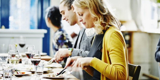 Woman dining with husband and friends at table in restaurant