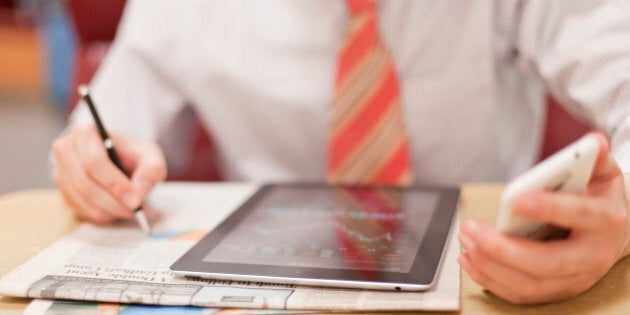 businessman studies China stock market with newspaper, mobile phone and Tablet PC