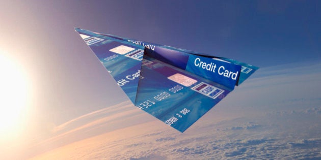 Credit card folded into paper airplane in atmosphere