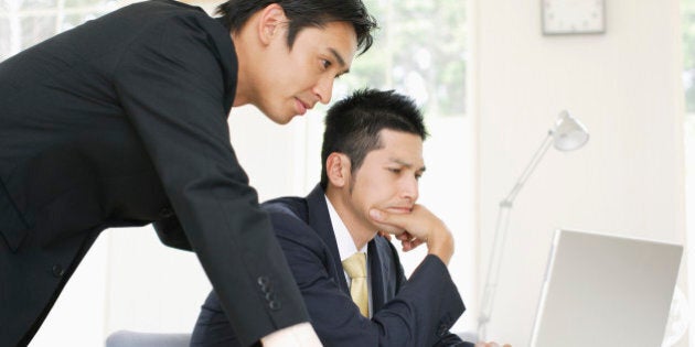 Businessmen looking at laptop PC screen