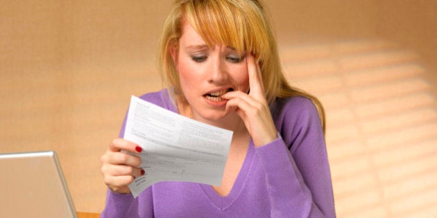 Teenager showing anxiety holding bill