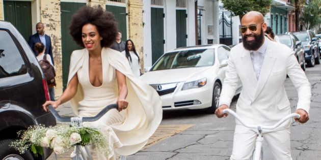 NEW ORLEANS, LA - NOVEMBER 16: Musician Solange Knowles (wearing a pre-ceremony ensemble by Stephane Rolland) and her fiance, music video director Alan Ferguson, ride bicycles on the streets of the French Quarter en route to their wedding ceremony at the Marigny Opera House on November 16, 2014 in New Orleans, Louisiana. (Photo by Josh Brasted/WireImage)