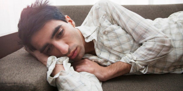 Man lying on sofa at home