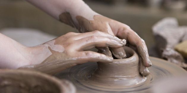 Hands closeup, working on pottery wheel with ceramics